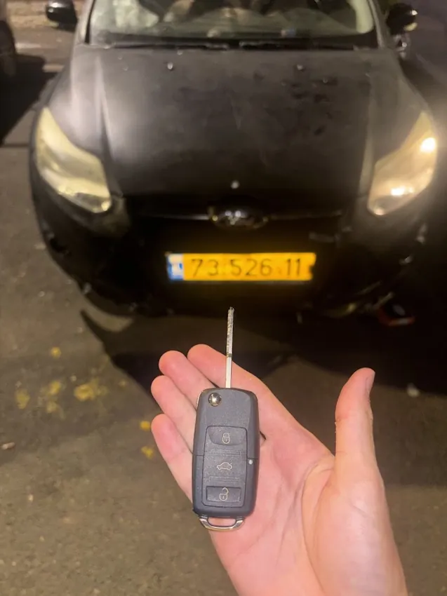מפתח ושלט מול רכב שחור
